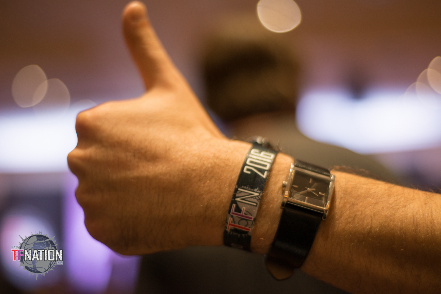 A picture of a TFNationals hand giving the thumbs up to the camera. On their wrist is the TFNation 2016 wristband.